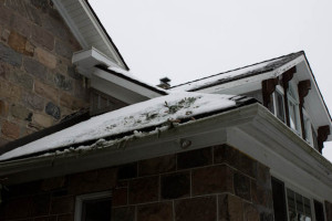 A bit of snow scraped off the roof, a bent eavestrough, and some inappropriately placed sprigs of spruce.
